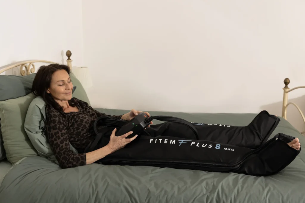 Femme allongée sur son lit pendant une séance avec le pantalon Fitem Plus 8